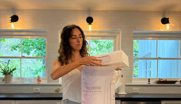 Woman unboxing the Aquafacial